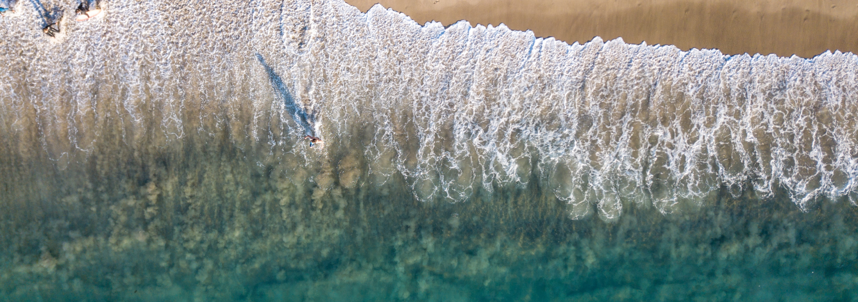 Top view of waves on a sand beach